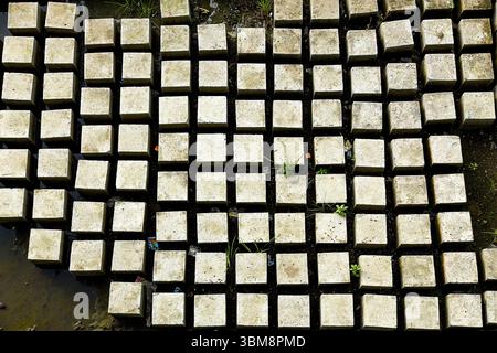 Una fotografia aerea che mostra un modello ordinato di blocchi di cemento rettangolari. Il layout geometrico crea un effetto visivo e ripetitivo Foto Stock