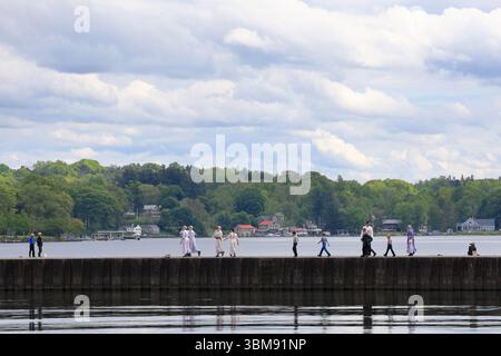 Sterling, New York, USA - 29 maggio 2025 - famiglia Amish che cammina lungo un molo di pesca nella parte occidentale di New York in una giornata primaverile. Foto Stock