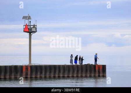 Sterling, New York, USA - 29 maggio 2025 - la famiglia Amish pesca da un molo nella parte occidentale di New York in una giornata primaverile. Foto Stock