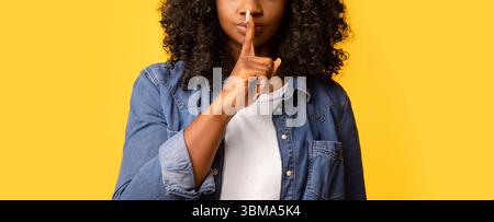 Bella donna che fa il gesto del silenzio con la mano Foto Stock