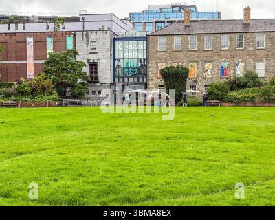 Dubh Linn Garden, un parco pubblico adiacente alla Chester Beatty Library, caratterizzato da un grande prato verde ed edifici storici a Dublino, Irlanda. Foto Stock