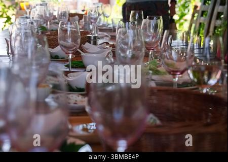 Tavolo di legno dopo la festa con piatti sporchi e cibo sprecato Foto Stock