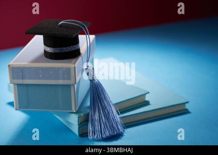 piccola malta con nappina blu sulla confezione regalo su sfondo blu Foto Stock
