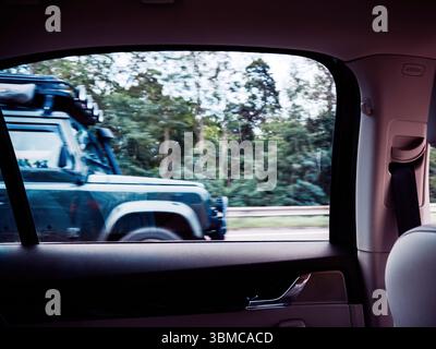 Boulogne, Francia - 24 agosto 2023: Vista laterale di un veicolo fuoristrada 4x4 che passa sull'autostrada, con alberi e guardrail visibili sul retro Foto Stock