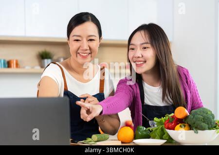 Cucina sana insieme. Due donne si godono una sessione di cucina con verdure fresche. Foto Stock