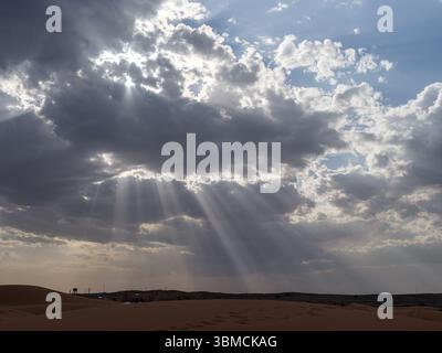 Marocco, Merzouga, 04 luglio 2025. Gli spettacolari raggi del sole che si infrangono attraverso le nuvole sul deserto del Sahara a Erg Chebbi, creando un paesaggio naturale mozzafiato Foto Stock