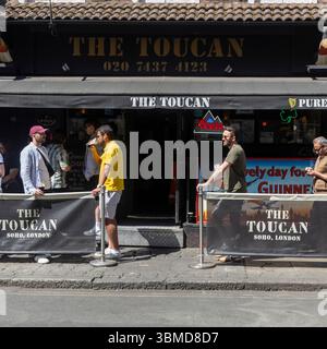 Londra, Regno Unito, 12 maggio 2025, un gruppo di persone diverse si riunisce fuori dal pub "The Toucan" a Soho, Londra, gustando un drink in una giornata di sole Foto Stock