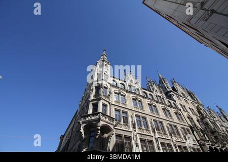 MONACO DI BAVIERA, GERMANIA - 24 GIUGNO 2025: Vista ad angolo basso della facciata del nuovo Municipio (Neues Rathaus) su Marienplatz sotto un cielo azzurro Foto Stock