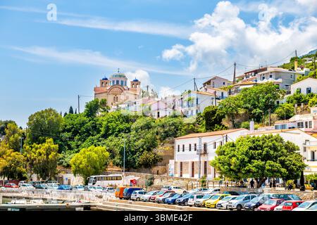 Agios Kirykos, Grecia - 24 maggio 2023: Città capitale, porto, paesaggio urbano sull'isola di Ikaria, Grecia, villaggio greco di zona blu con chiesa in cima alla collina Foto Stock