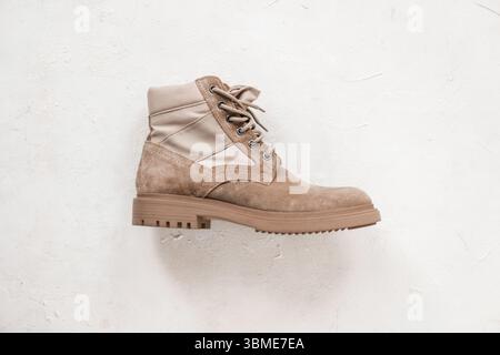 Un elegante stivale stringato in pelle scamosciata beige su sfondo bianco. Primo piano. Eleganti calzature da uomo. Moda primaverile. Foto Stock