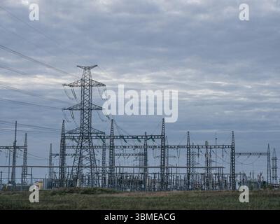 Sottostazione elettrica ad alta tensione sotto il cielo nuvoloso Foto Stock