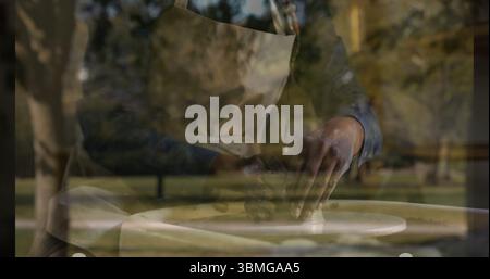 vasaio donna che indossa un grembiule che forma l'argilla bagnata su una ruota di ceramica al tavolo di legno nel parco Foto Stock