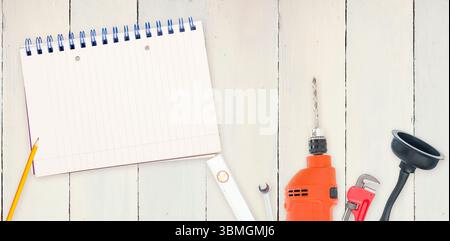Strumenti e blocco note su sfondo di legno Foto Stock