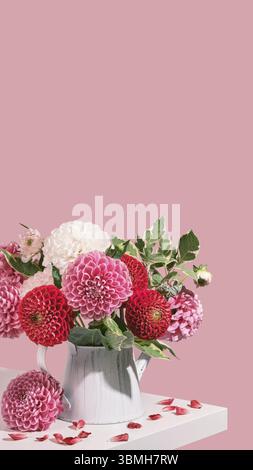 Bouquet autunnale di splendidi fiori di dahlia su tavolo bianco, colori rosa, vista isometrica. Formato verticale delle storie Smartpone Foto Stock