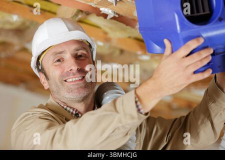 Tecnico di impianti di termoventilazione pronto per installare il sistema di ventilazione in casa Foto Stock