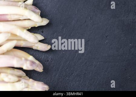 Asparagi bianchi (close-up shot) su una lastra di ardesia (messa a fuoco selettiva) Foto Stock