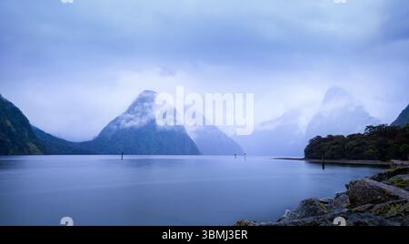 Picco ad angolo avvolto da nuvole. Milford Sound. Parco nazionale di Fiordland. Isola del Sud. Nuova Zelanda. Foto Stock
