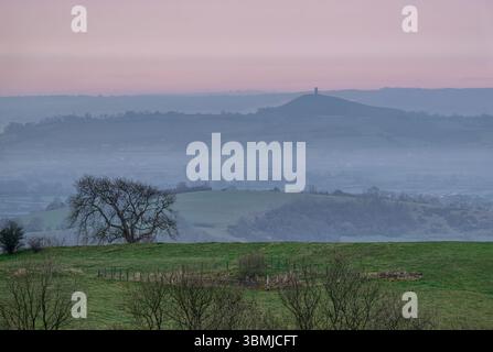 Vista dell'alba dalle Mendip Hills nel Somerset, con vista sui Somerset Levels e sulla Glastonbury Tor Foto Stock
