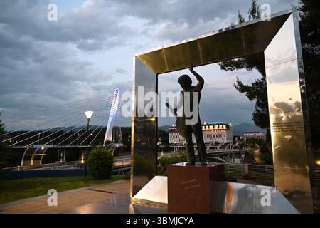 Podgorica, Montenegro - 20 giugno 2025: Monumento a Vladimir Vysotsky e Millennium Bridge a Podgorica. Foto Stock