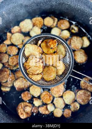 Frittura e preparazione di fette di melanzane in olio, vista dall'alto, cibo tradizionale arabo. Foto Stock