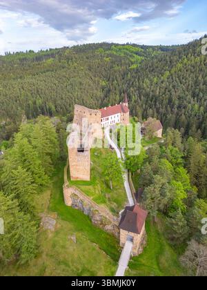 Il drone cattura il castello di Velhartice circondato da fitte foreste nella Repubblica Ceca. Questo sito storico presenta impressionanti strutture in pietra e un sentiero tortuoso che mostra la bellezza panoramica. Foto Stock