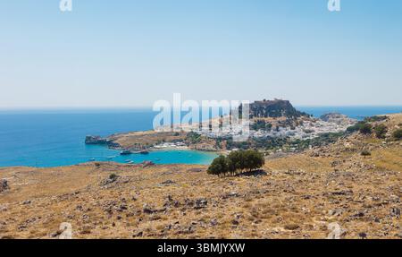 Lindos village on the island of Rhodes in Greece. Panoramic view over Lindos beach, village with whitewashed houses. The Lindos Acropolis. Foto Stock