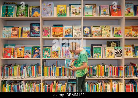 Paesi Bassi, bambini che leggono libri in una biblioteca pubblica Foto Stock