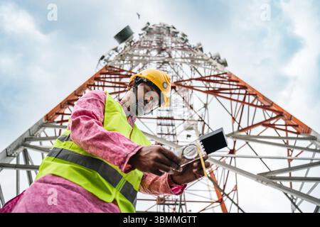 Tecnici che si arrampicano su una torre di rete con dispositivi di sicurezza, risoluzione dei problemi relativi alla torre di rete mobile, torre di telefonia mobile, antenna radio, rete wireless Foto Stock
