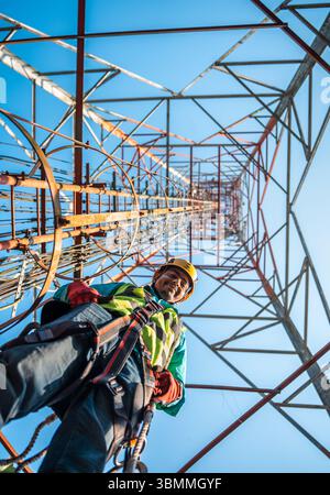 Tecnici che si arrampicano su una torre di rete con dispositivi di sicurezza, risoluzione dei problemi relativi alla torre di rete mobile, torre di telefonia mobile, antenna radio, rete wireless Foto Stock