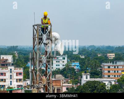 Tecnici che si arrampicano su una torre di rete con dispositivi di sicurezza, risoluzione dei problemi relativi alla torre di rete mobile, torre di telefonia mobile, antenna radio, rete wireless Foto Stock