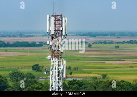 Tecnici che si arrampicano su una torre di rete con dispositivi di sicurezza, risoluzione dei problemi relativi alla torre di rete mobile, torre di telefonia mobile, antenna radio, rete wireless Foto Stock