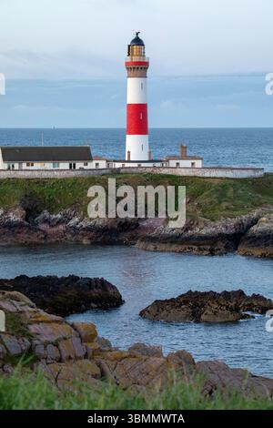 Un faro scozzese ben tenuto, con la bassa marea, dipinto in rosso e bianco. Sulla costa dell'Aberdeenshire in Scozia. Foto Stock