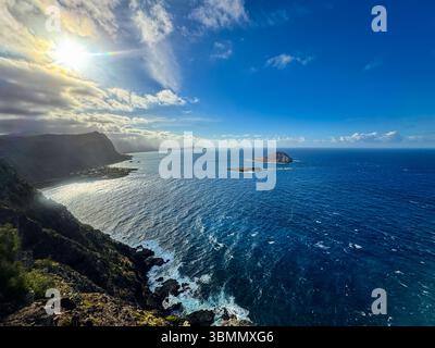 Splendida vista aerea di Rabbit Island dal faro Makapu'u, Oahu: Le onde turchesi del Pacifico si infrangono lungo la spettacolare costa vulcanica e il cielo vibrante Foto Stock