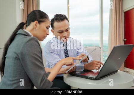 Riunione aziendale che prevede la collaborazione con un notebook e un tablet digitale Foto Stock