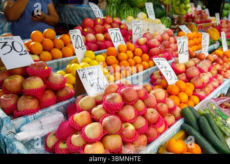 Mele, arance, limoni e cetrioli esposti al mercato ortofrutticolo delle Filippine con indicazione dei prezzi Foto Stock