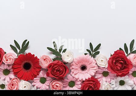 Florale Zusammensetzung von Rosen und Gerberas auf grauem Hintergrund. Arrangiamento von schoenen Blumen Foto Stock