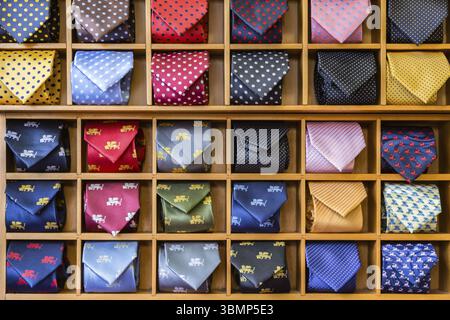 Vetrina con cravatte multicolore. Vista di diversi colori cravatte in vetrina. Uomo multicolore. Vetrina di cravatte arrotolate in negozio. Le lege avvolte Foto Stock