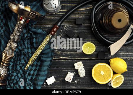 Vista superiore del narghilè con frutta di arancia su uno sfondo di legno. Lay piatto. Copia dello spazio. Still Life Foto Stock