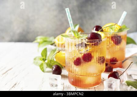 Drink estivo fresco. Bevanda rinfrescante ghiacciata, limonata di cola alla ciliegia all'arancia o cocktail di mojito in bicchiere su un tavolo di legno. Copia spazio Foto Stock