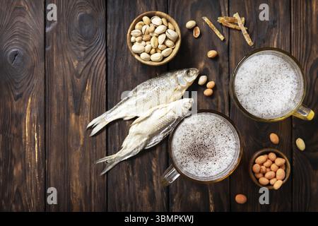 Bevanda alcolica pinta di lager e pinta di stout, birra artigianale. Due bicchieri di birra con schiuma e spuntini su sfondo rustico in legno. tradizionale tedesco wh Foto Stock