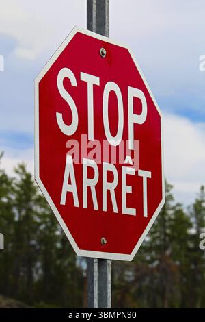 Un segnale di stop scritto sia in inglese che in francese Foto Stock