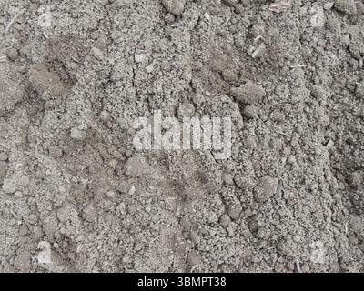 macchie di terra terreno fertile da vicino, terreno arato fresco, terreno agricolo nelle vicinanze, terreno arabile con terreno grigio friabile Foto Stock