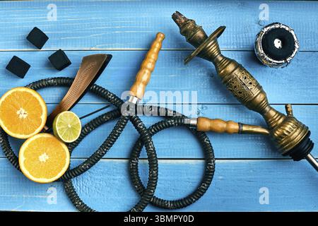 Parti del narghilè blu su sfondo di legno. Il tabacco con arancia e tiglio sapore. Vista dall'alto. Lay piatto. Copia dello spazio. Still Life Foto Stock