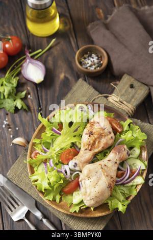 Carne di pollo alla griglia con lattuga verde fresca, cetrioli, pomodoro e cipolla rossa. Pranzo a base di chetogeni, cheto o paleo Foto Stock