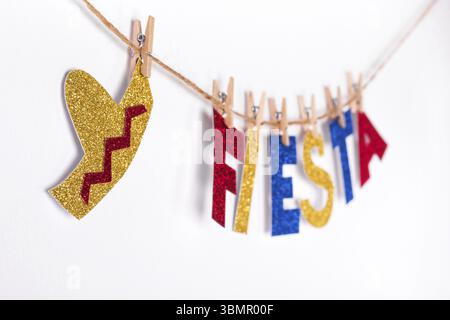 Fiesta parola e sombrero in carta lucida su spille. Frammento di festoso DIY Garland di interiore. Cinco de mayo celebrazione Foto Stock