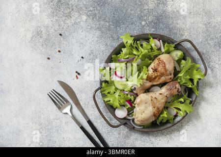 Mangiare sano e pulito. Carne con insalata fresca. Bastoncini di pollo al forno e un'insalata vegana verde a base di foglie verdi e verdure primaverili su a s Foto Stock