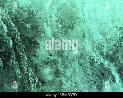 Muro di pietra con luce neon su sfondo scuro. Riflessione di luci Neon Foto Stock