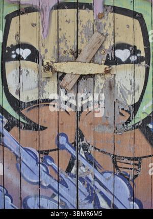 Lucchetto che fissa la porta in legno con graffiti e cuori di cartoni animati Foto Stock