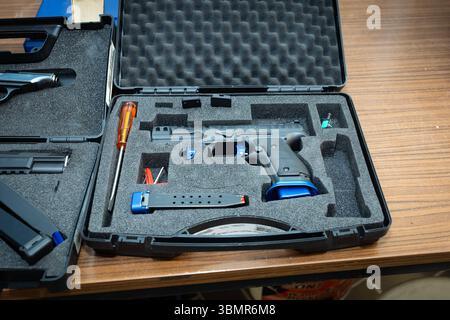Landkreis Osnabrück, Deutschland 25. Juni 2025: IM Bild: Ine moderne Walther Sportpistole, eine hochpräzise Kurzhandwaffe für den Wettkampfsport, liegt sicher in einem geöffneten, gepolsterten Transportkoffer. Die pistole ist schwarz mit auffälligen blauen Akzenten am Griff und Magazin, era auf ein spezialisiertes Wettkampfmodell hindeutet. Neben der pistole sind im Schaumstoff-Inlay des Koffers weitere Zubehörteile wie ein langes Magazin, ein Schraubendreher und kleine blaue Werkzeuge oder Ersatzteile präzise angeordnet. Der Koffer gewährleistet den sicheren Transport und die geschützte Aufbe Foto Stock
