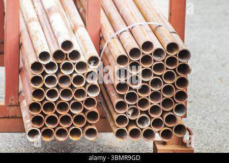 Pila di tubi in acciaio per ponteggi in magazzino Foto Stock